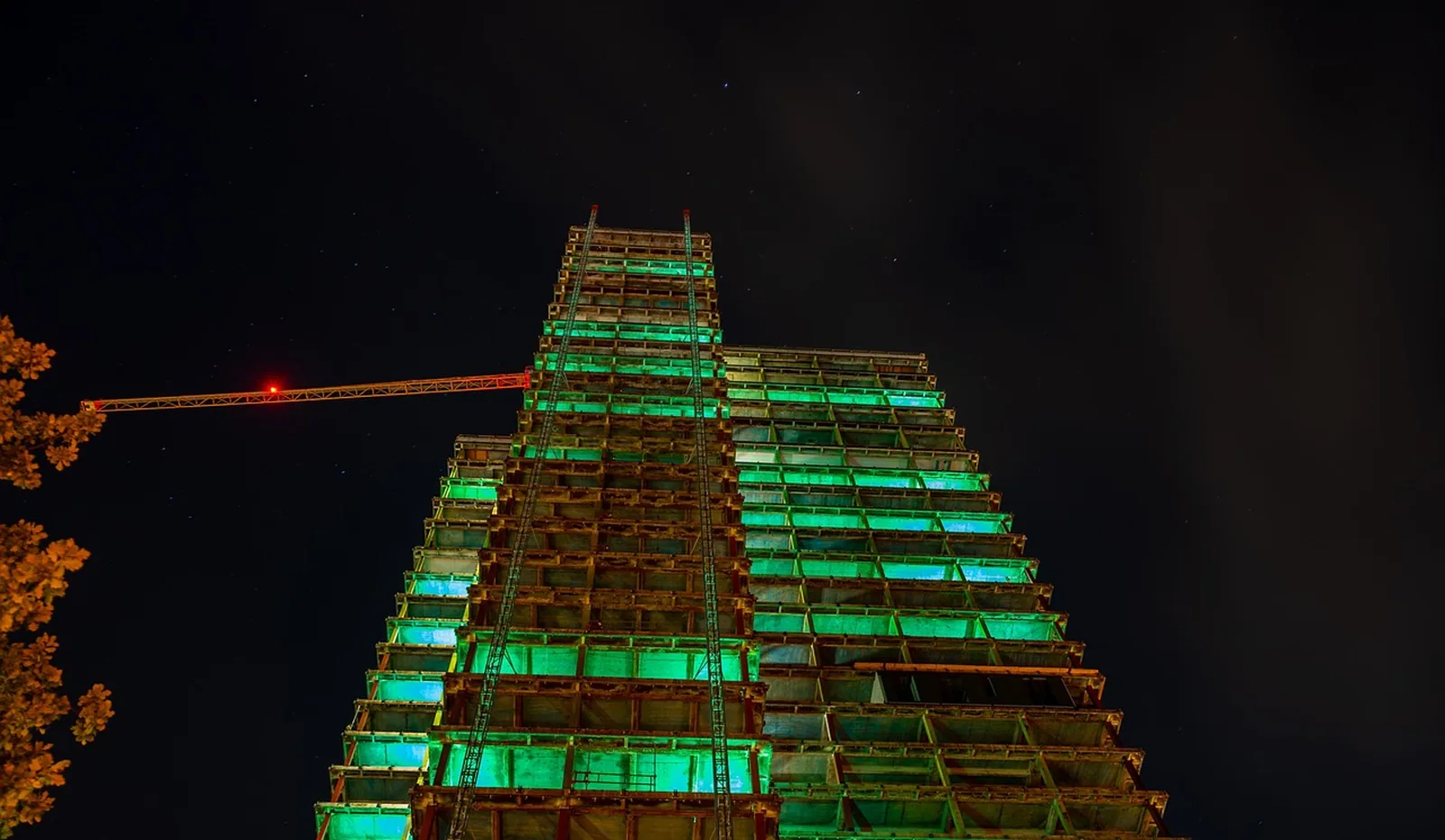Beleuchtete Baustelle eines mehrgeschossigen Gebäudes bei Nacht