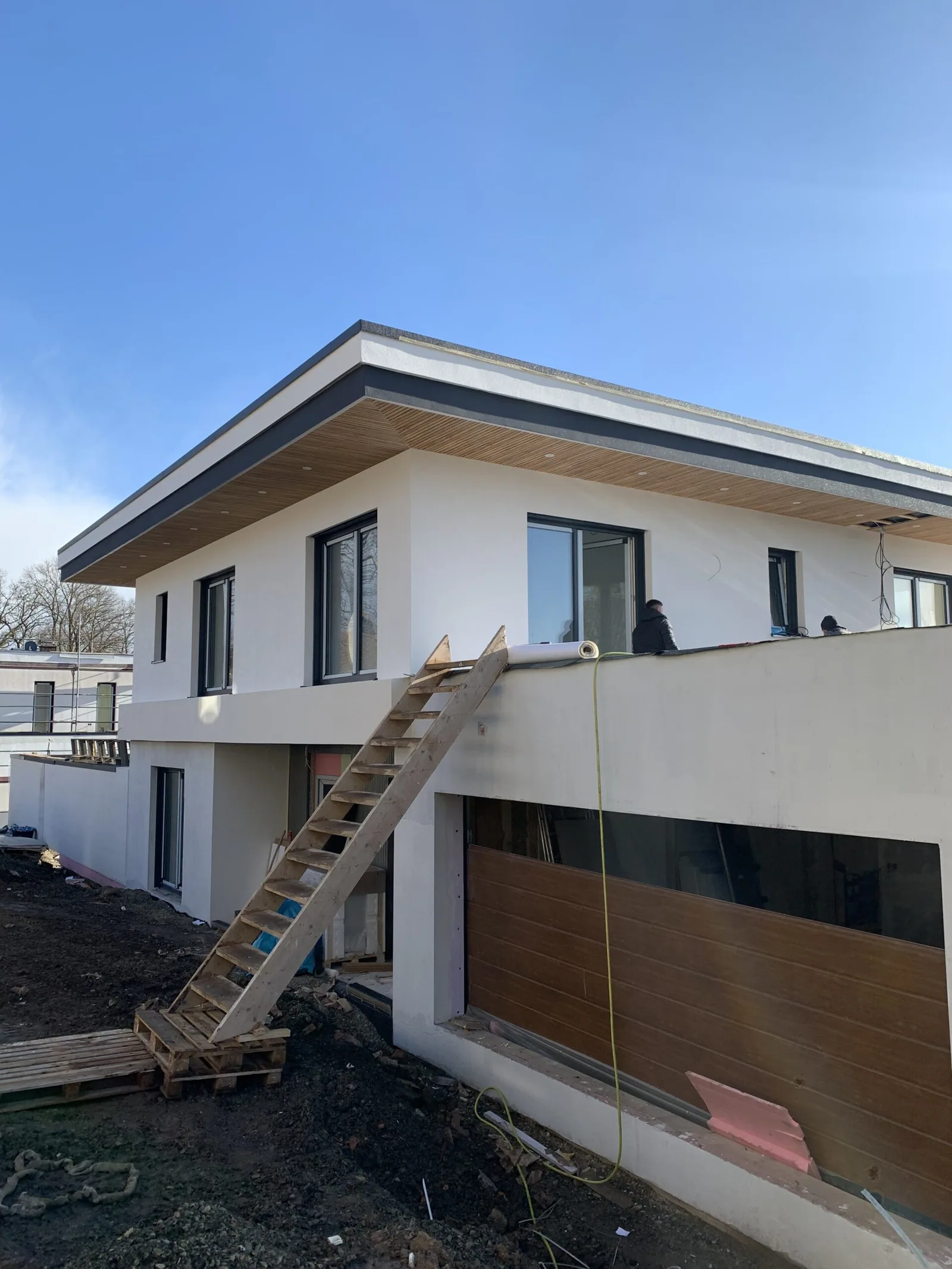 Wohnhaus im Rohbauzustand mit geschlossener Fassade und gesetzten Fenstern