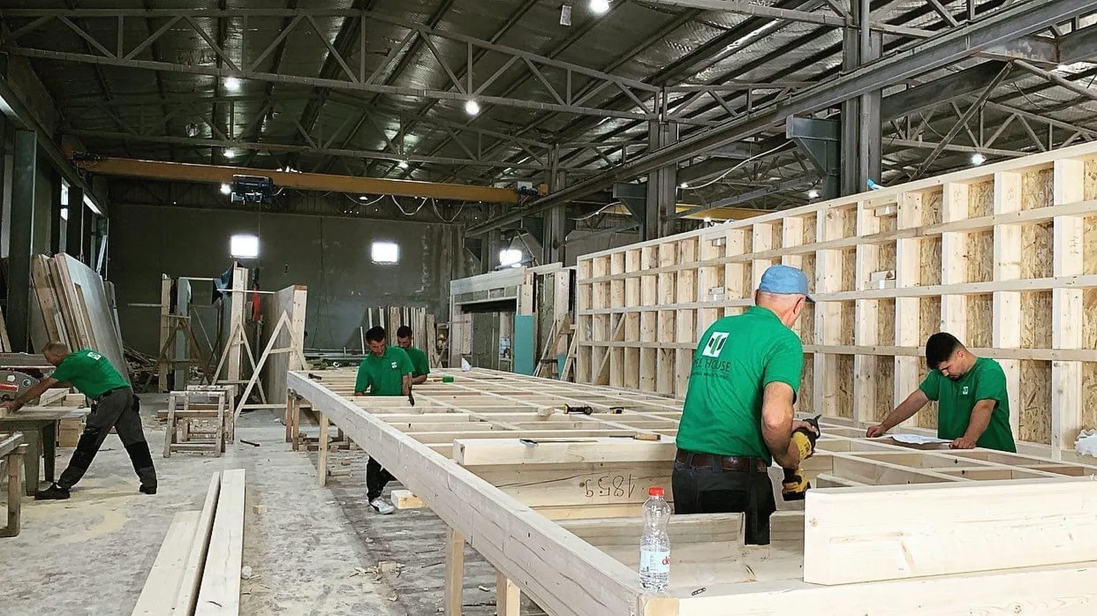 Mitarbeiter beim Abbinden eines Deckenelements in der Fertigungshalle